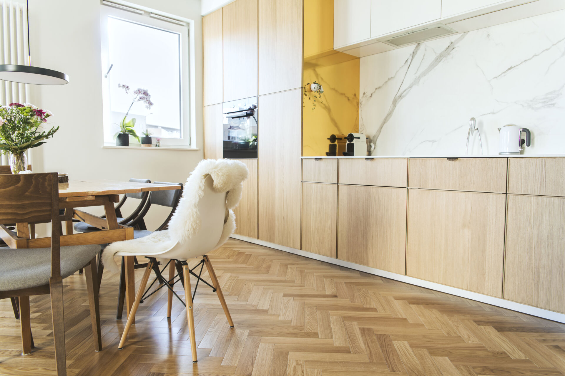Kitchen with light coloured laminate chevron flooring
